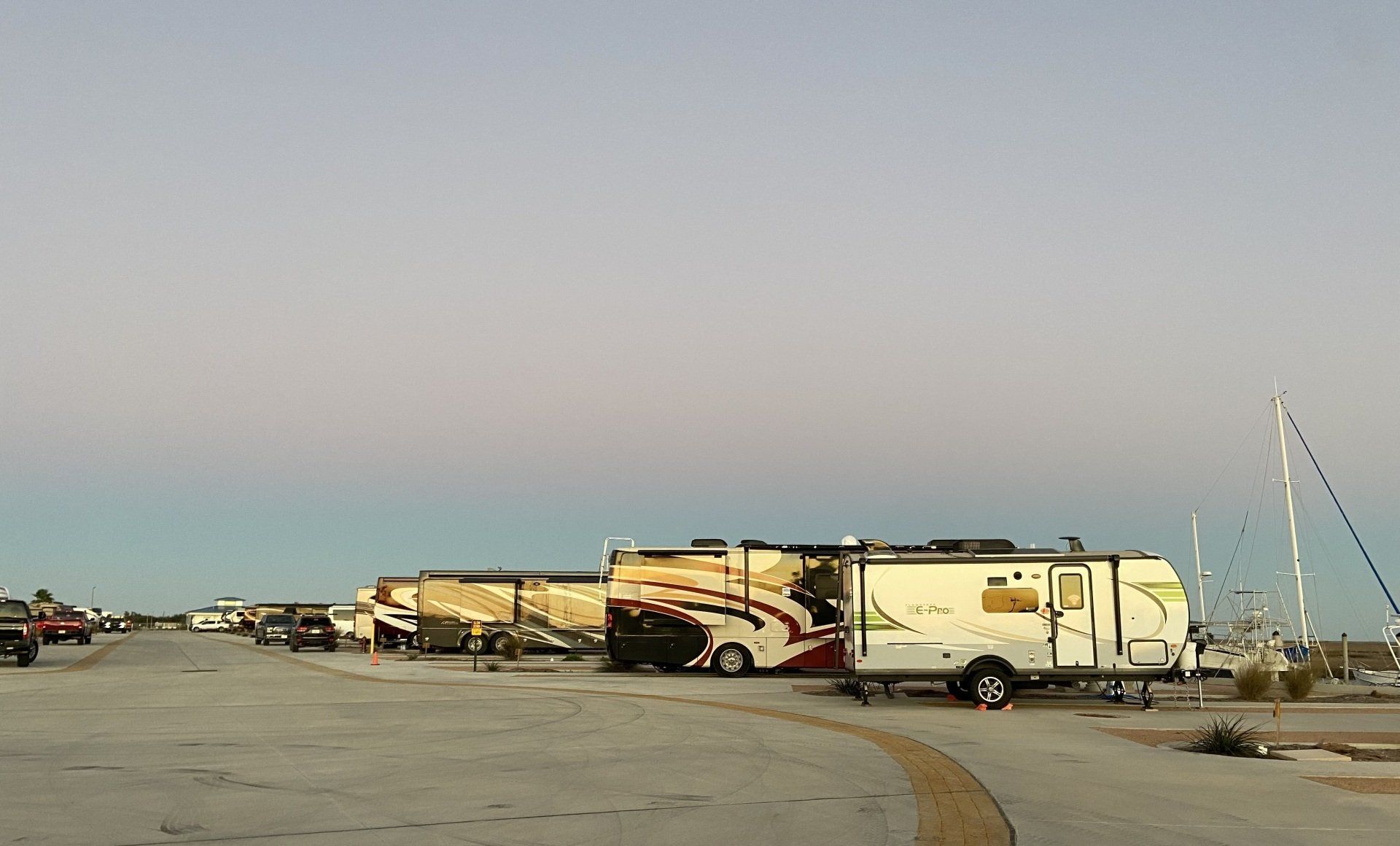 A row of rvs are parked in a parking lot