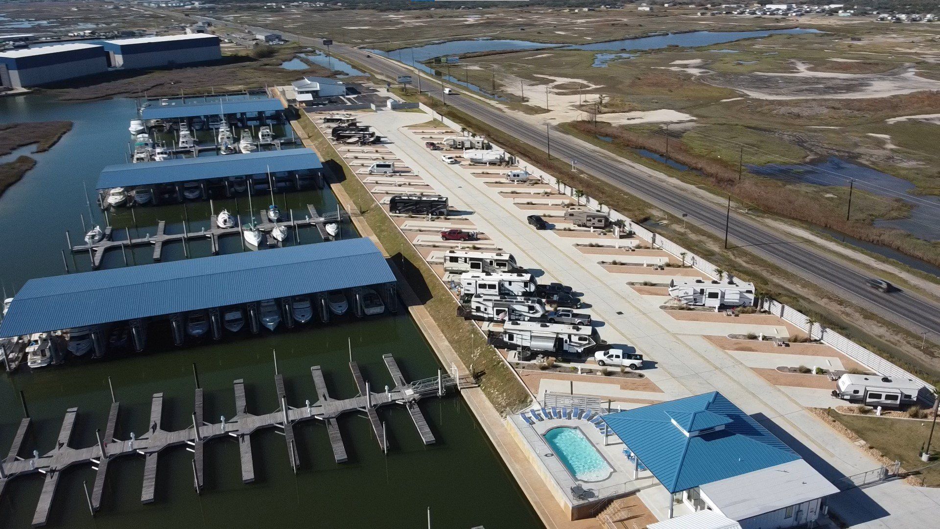 An aerial view of a marina with boats docked and a swimming pool.
