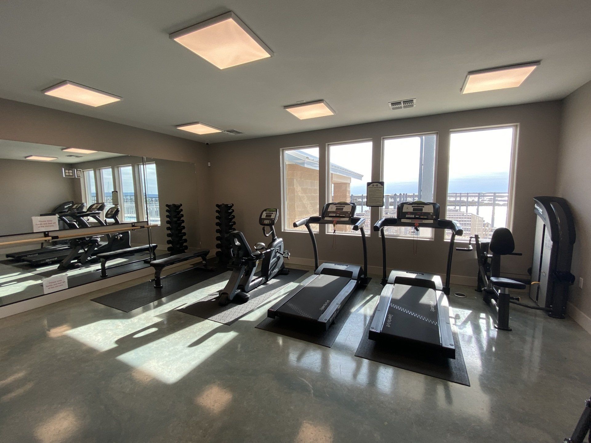 A gym with treadmills and a large mirror