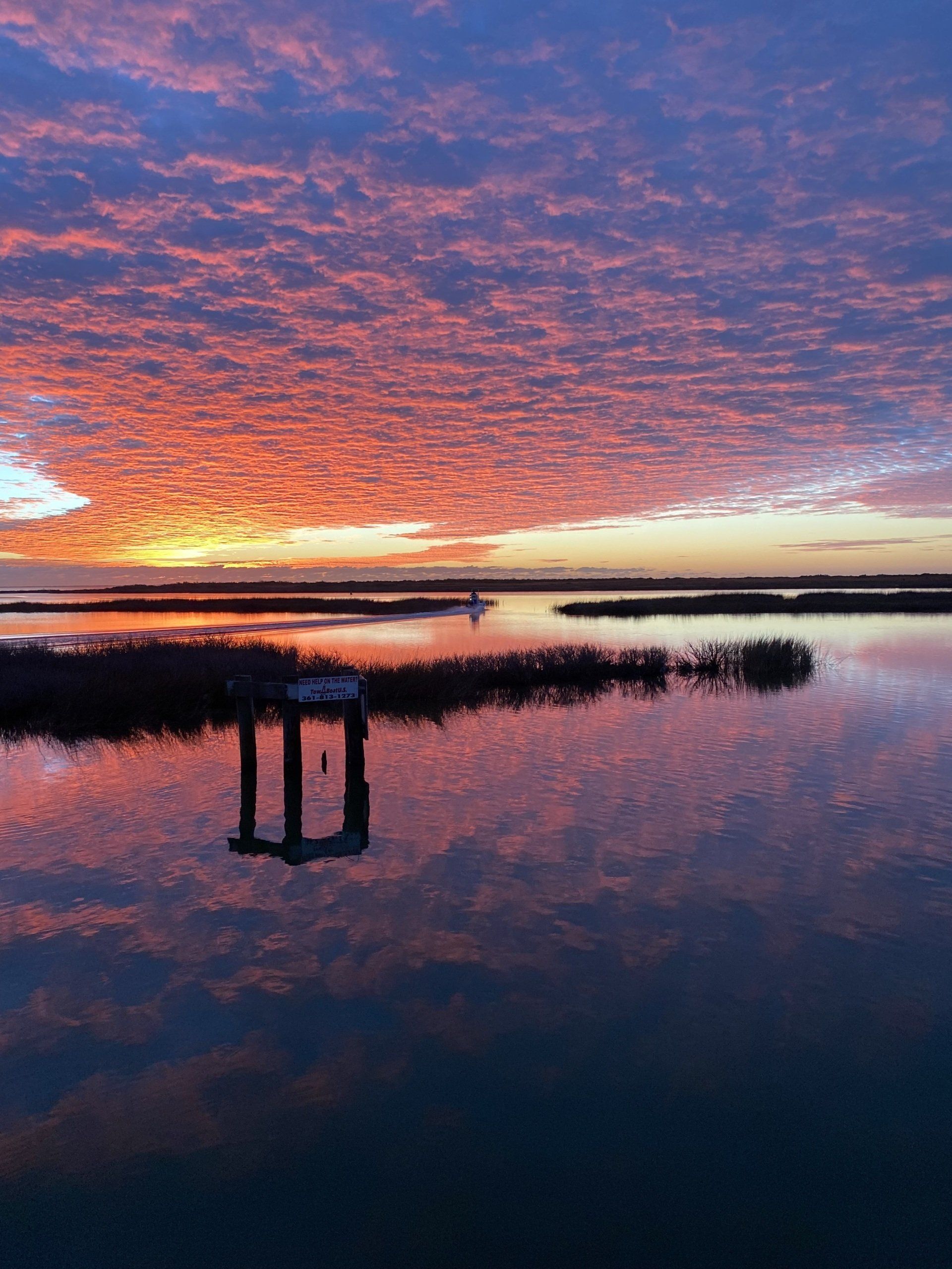 A sunset over a body of water with a dock in the foreground.