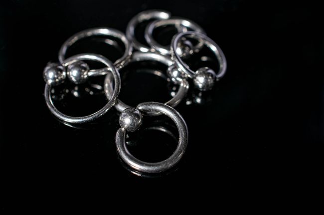 Silver metal rings with small beads on a black background