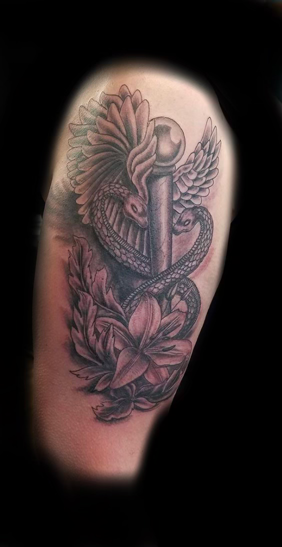 Tattoo artist wearing black gloves inks a floral tattoo on skin with a needle