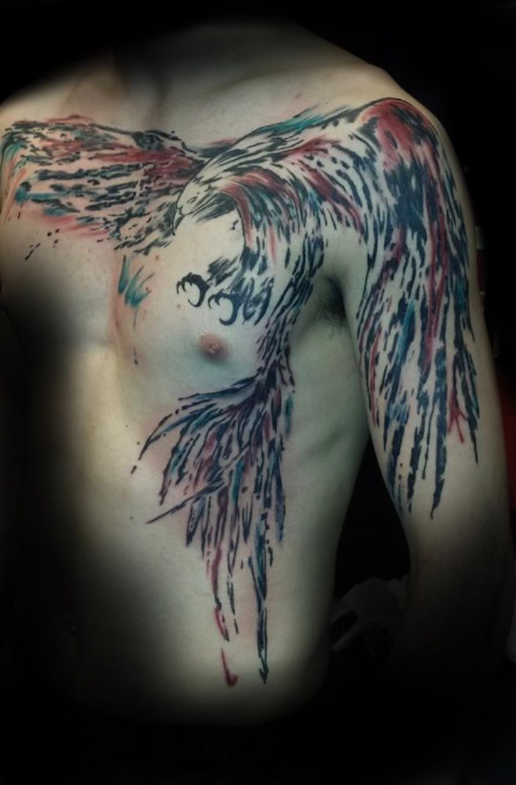 Tattooed forearm raised against a dark gray background, showing colorful geometric and floral ink