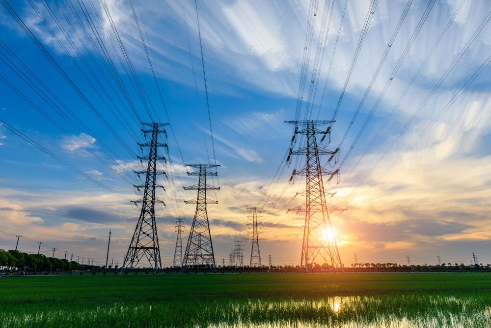 Power Lines at Sunset Over a Green Field Under a Blue, Cloud-streaked Sky — Darwin Electrical Services in Humpty Doo, NT