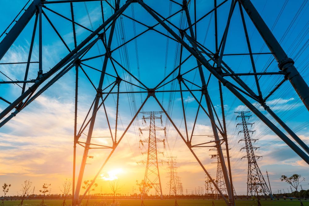 Power Lines and Transmission Towers Silhouetted Against a Sunset Sky — Darwin Electrical Services in Palmerston, NT