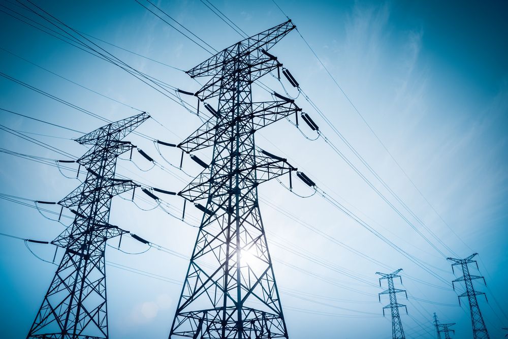 High-voltage Power Transmission Towers and Lines Against a Blue Sky — Darwin Electrical Services in Rural & Remote, NT