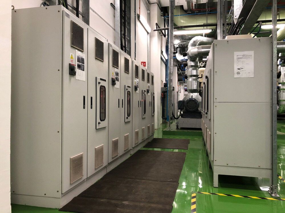 Electrical Control Panels and Equipment in a Utility Room With Green Flooring — Darwin Electrical Services in Palmerston, NT