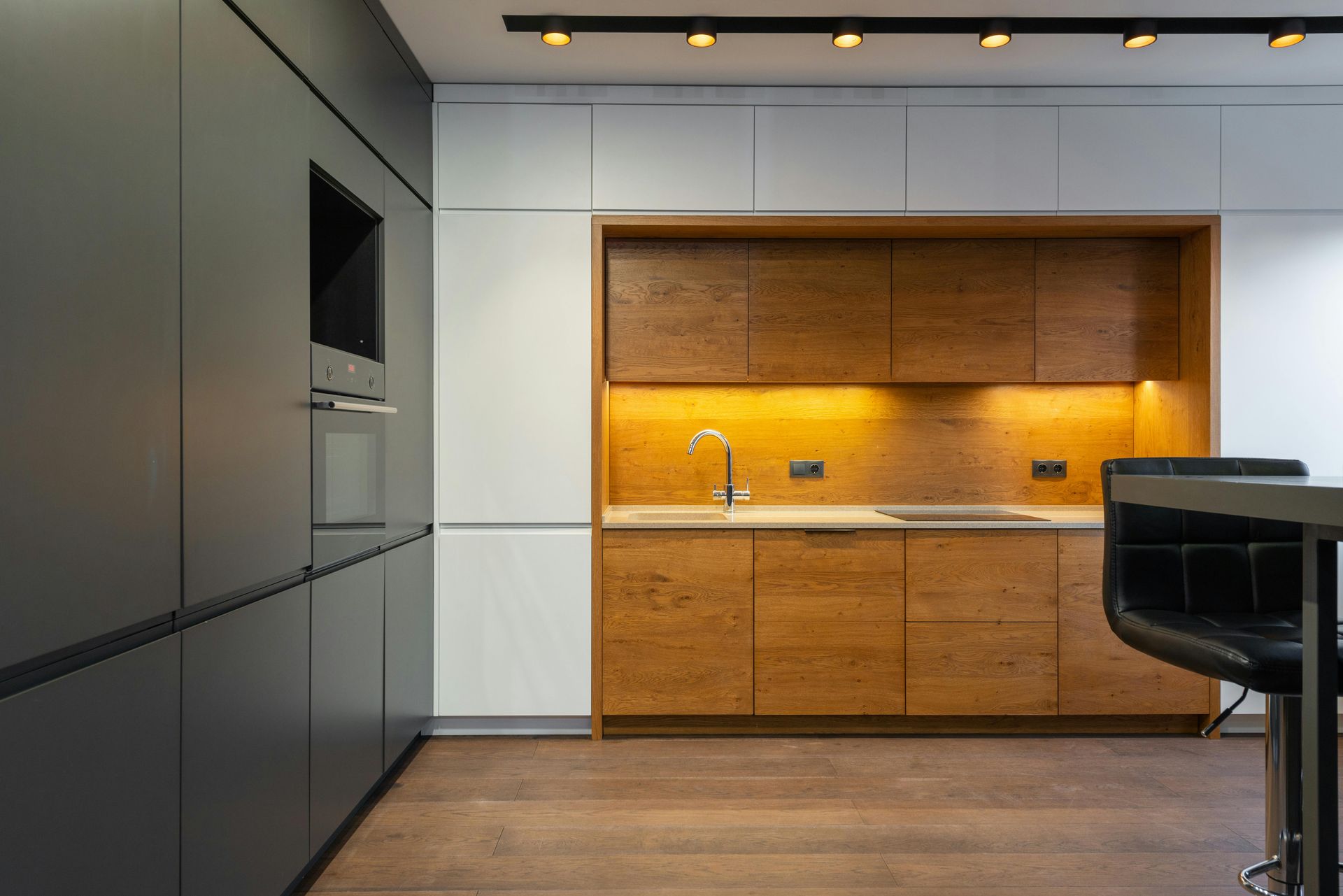 Modern kitchen featuring dark grey cabinets, a white wall — Darwin Electrical Services in Humpty Doo, NT