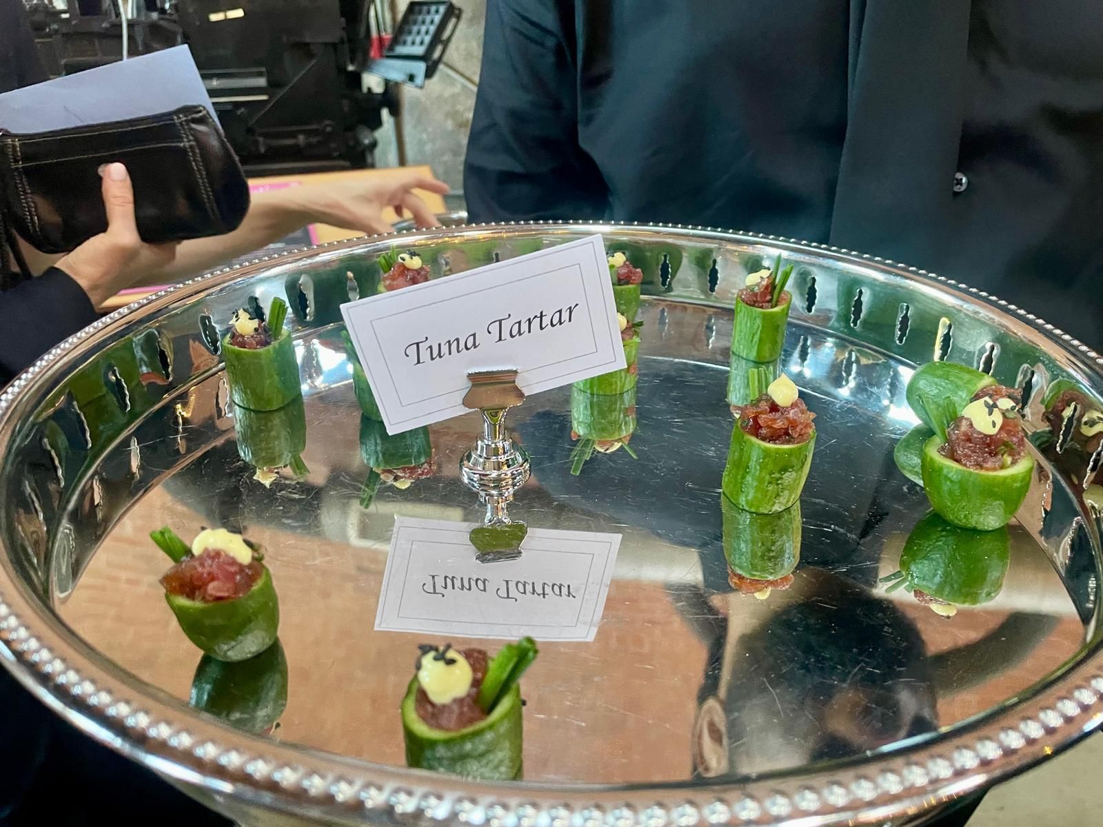 Silver tray with tuna tartare appetizers on cucumber rounds.