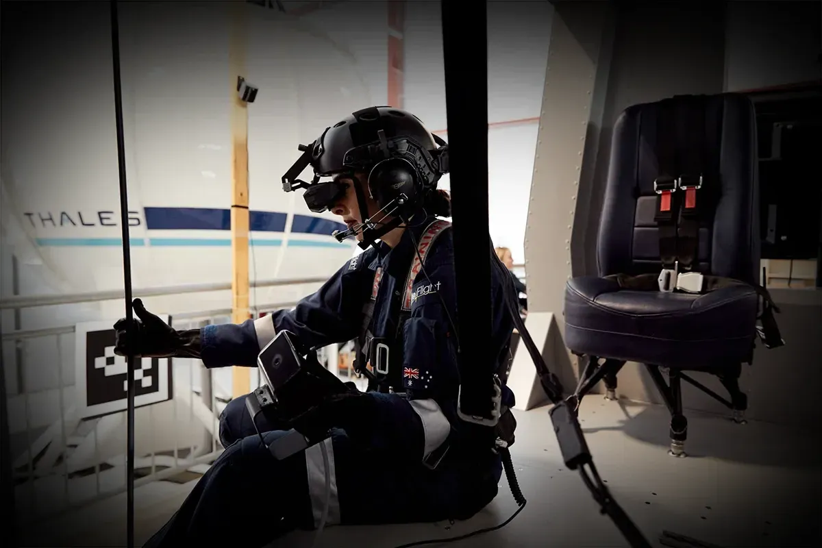 Rear crew member wearing a mixed reality headset in the AW-139 rear crew trainer cabin