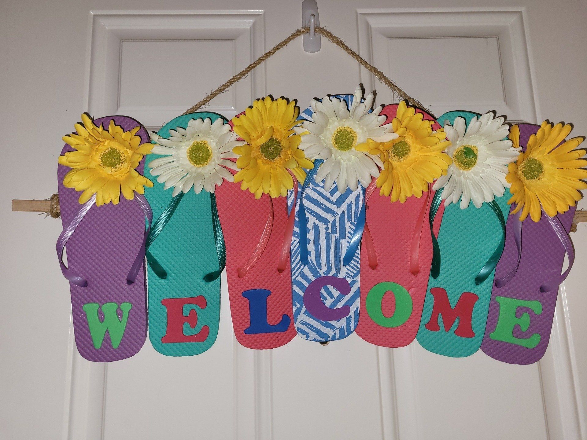 A welcome sign made out of flip flops and flowers