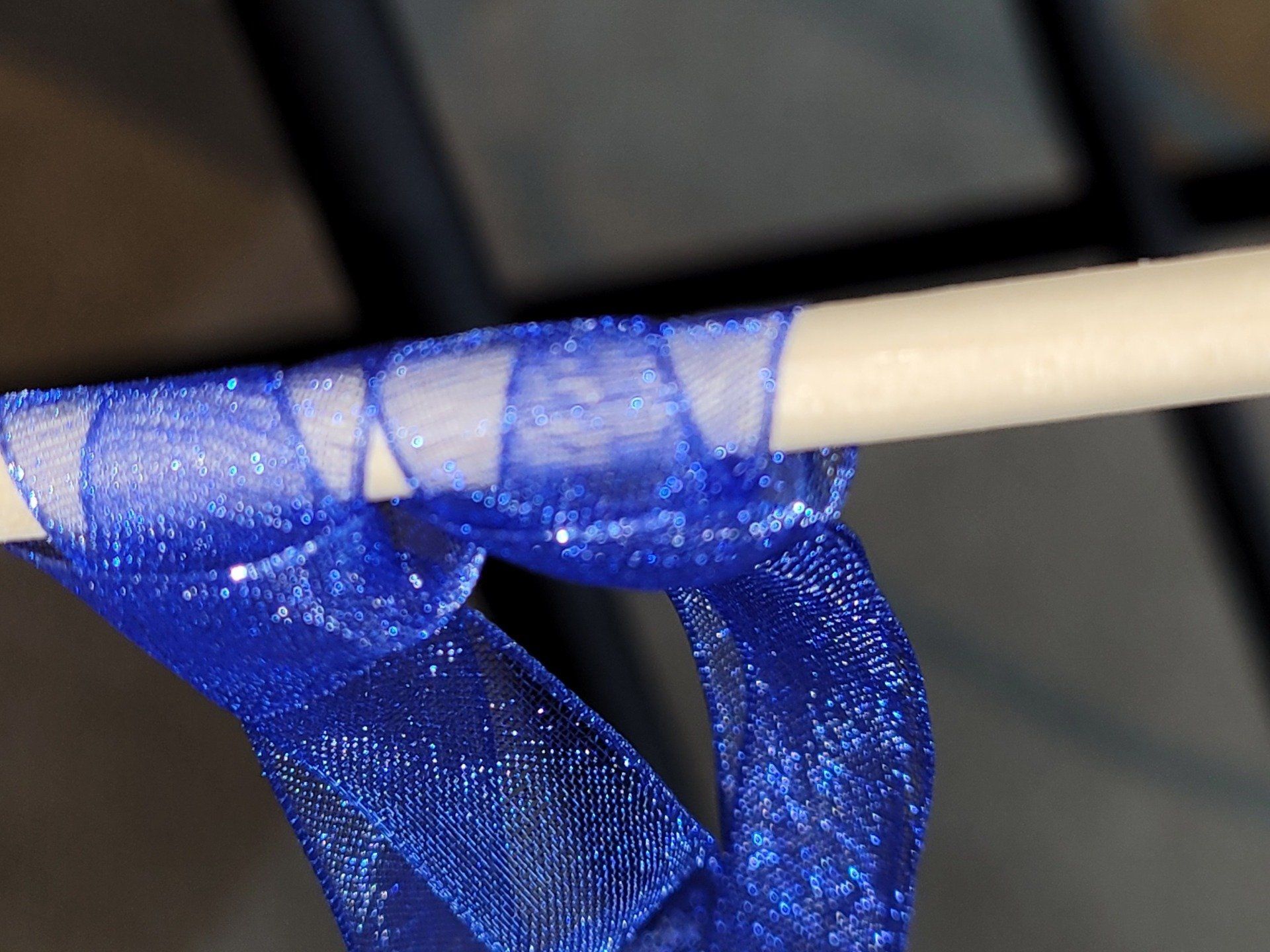 A blue ribbon is tied to a wooden stick