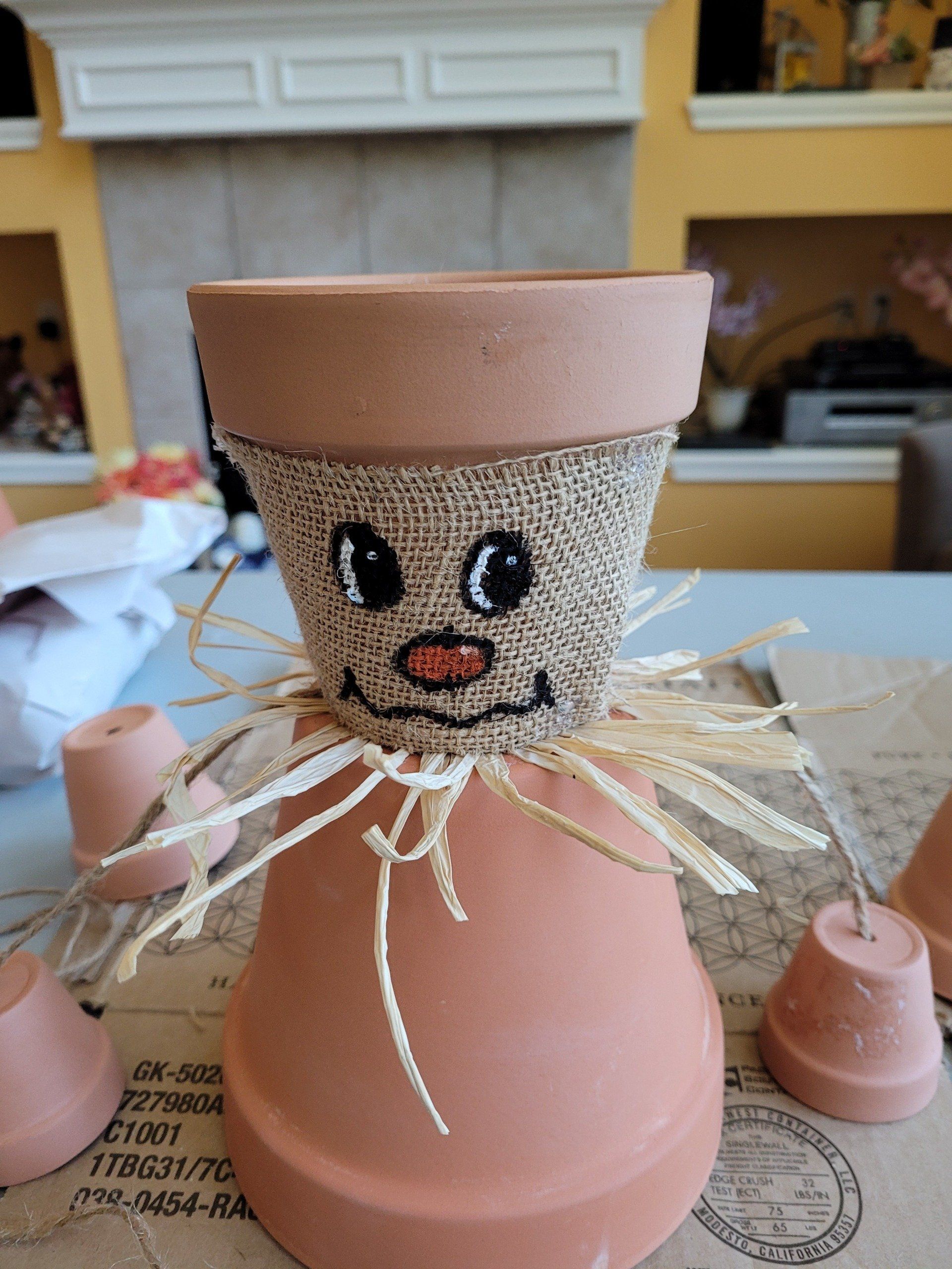 A clay pot decorated to look like a scarecrow