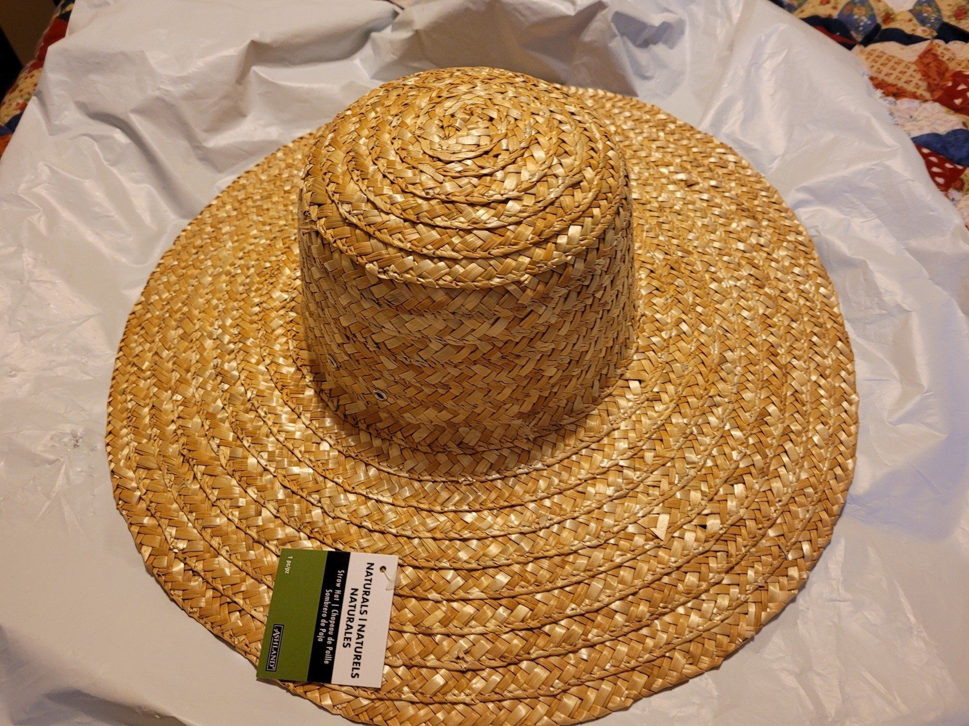 A straw hat is sitting on a white cloth