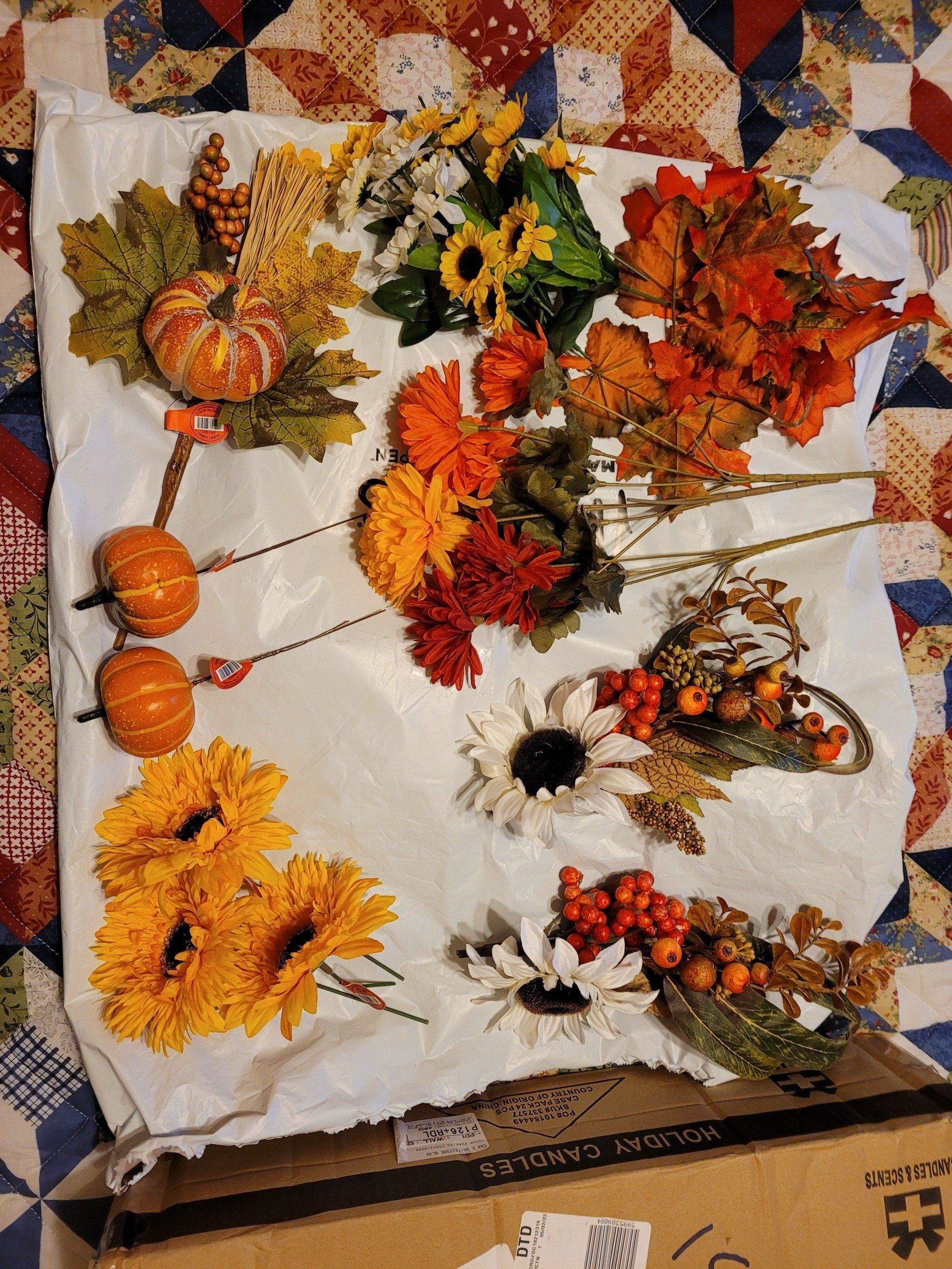 There are many different types of flowers and leaves on the table.