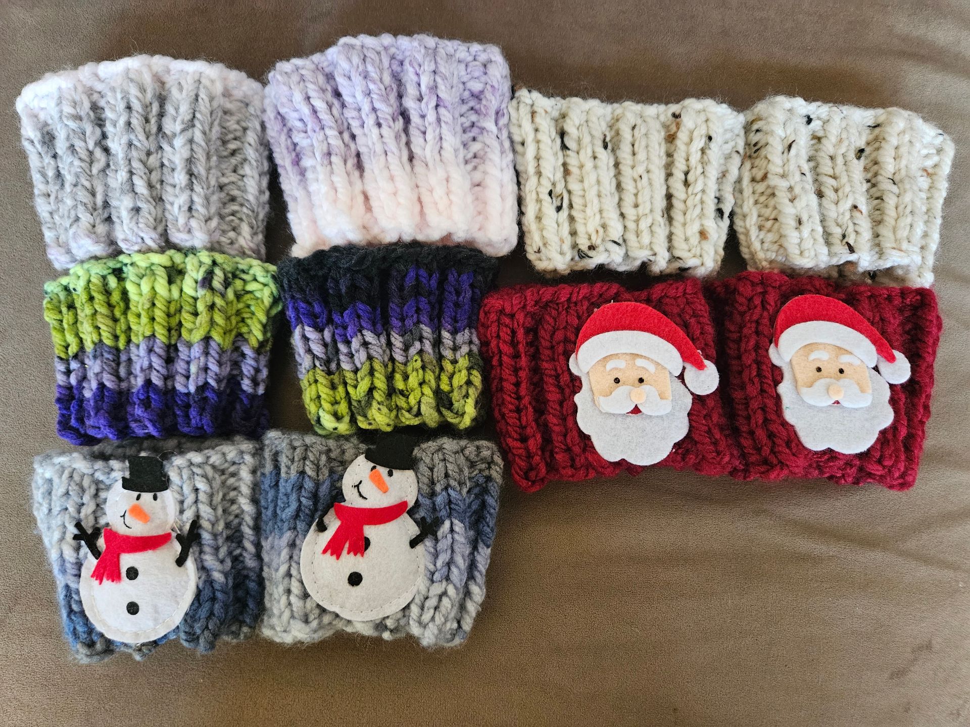 A row of knitted mittens with santa claus and snowmen on them