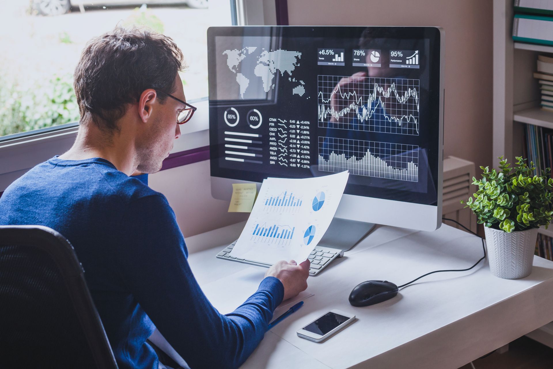 A man is sitting at a desk in front of a computer.