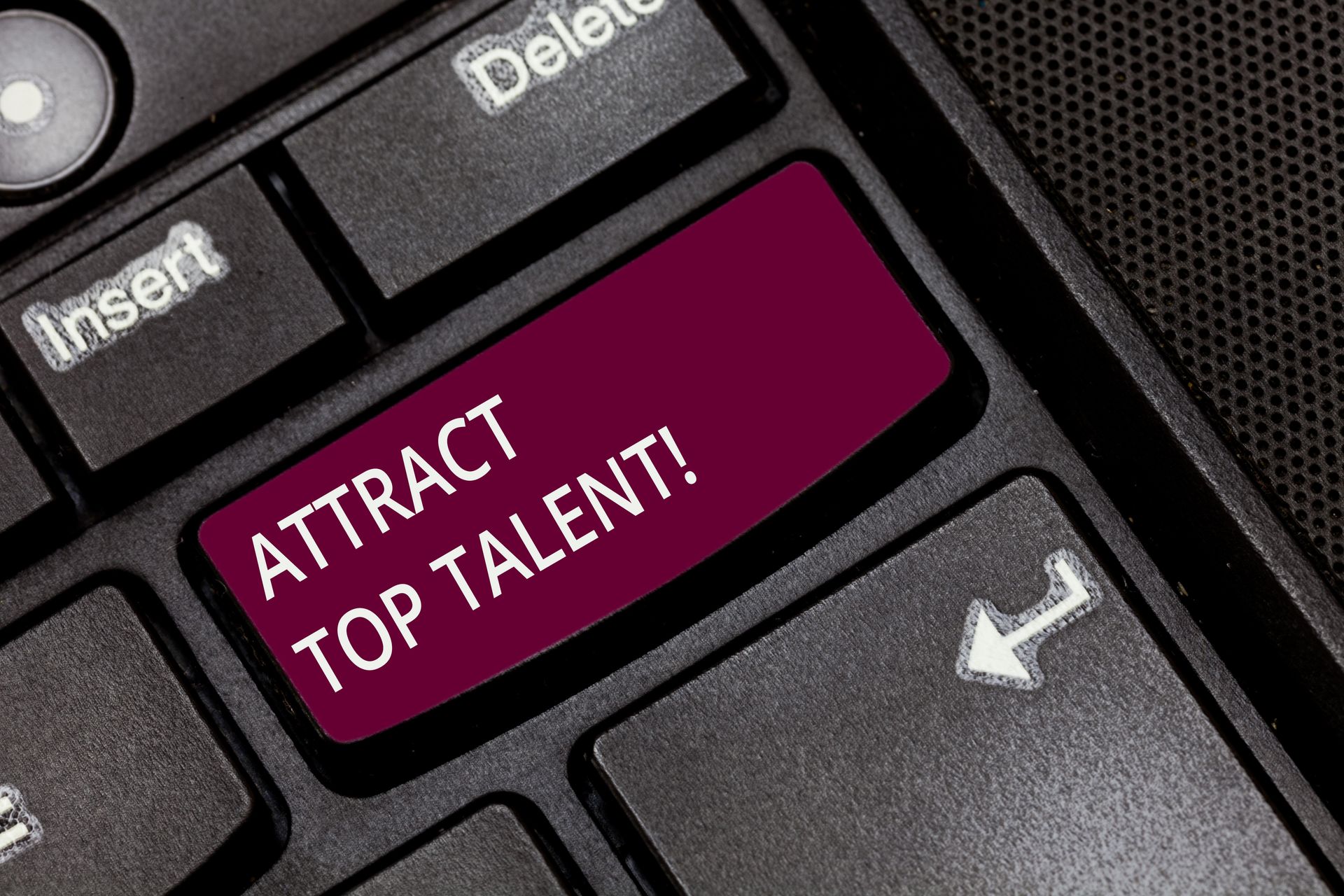 A keyboard with a red button that says attract top talent