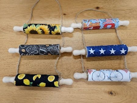 A bunch of rolling pins hanging from a string on a wooden table.