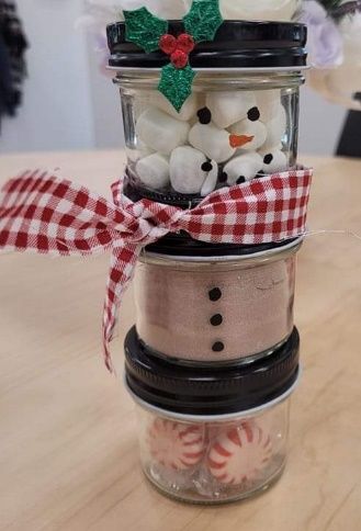 A stack of mason jars filled with marshmallows and peppermints.