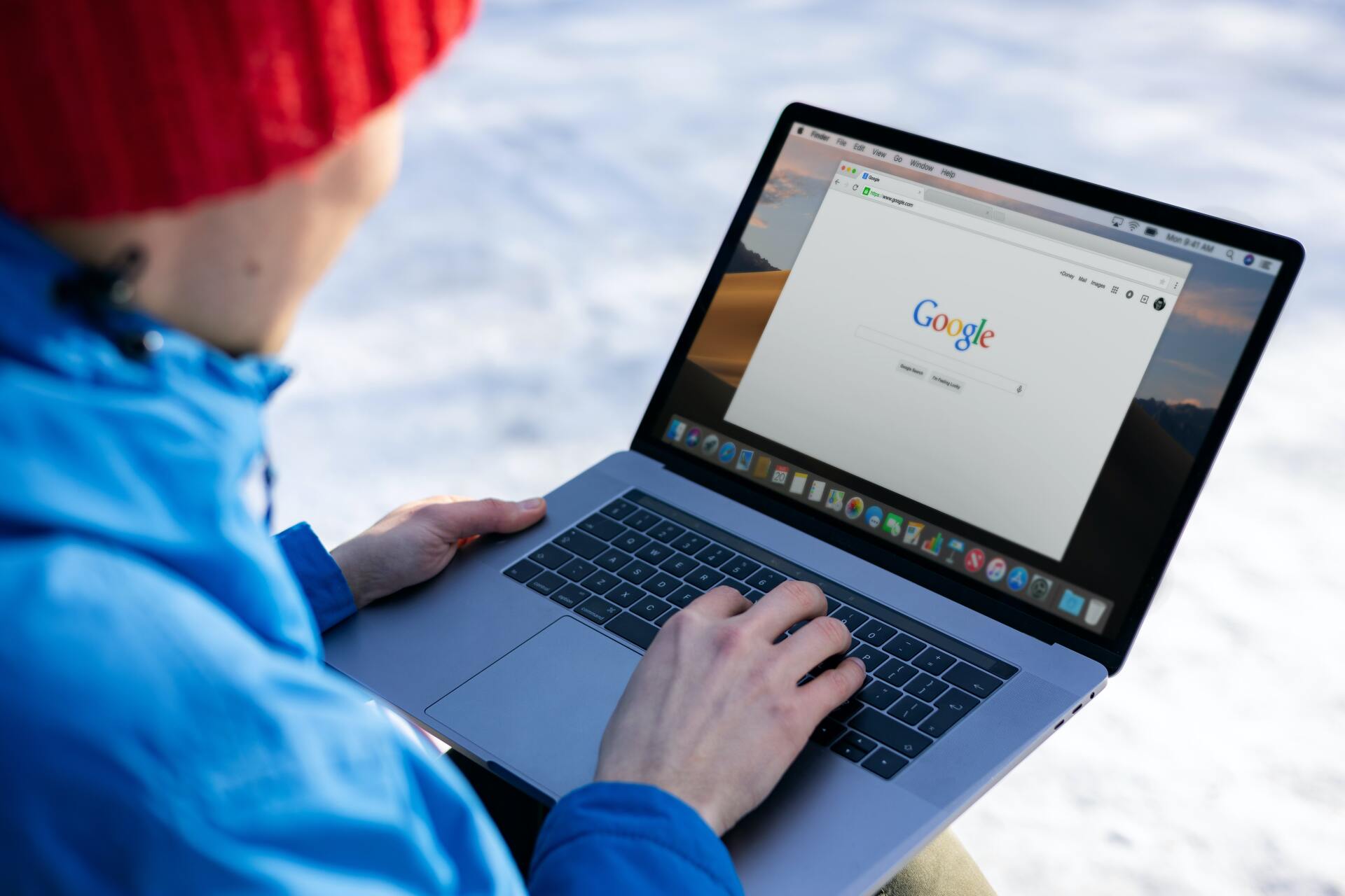 A person is using a laptop computer in the snow.