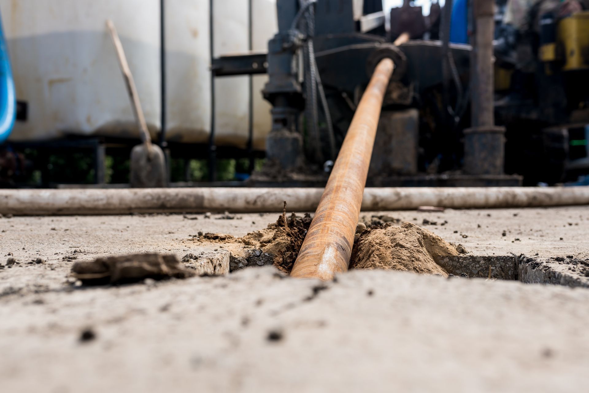 A wooden stick is sticking out of a hole in the ground.