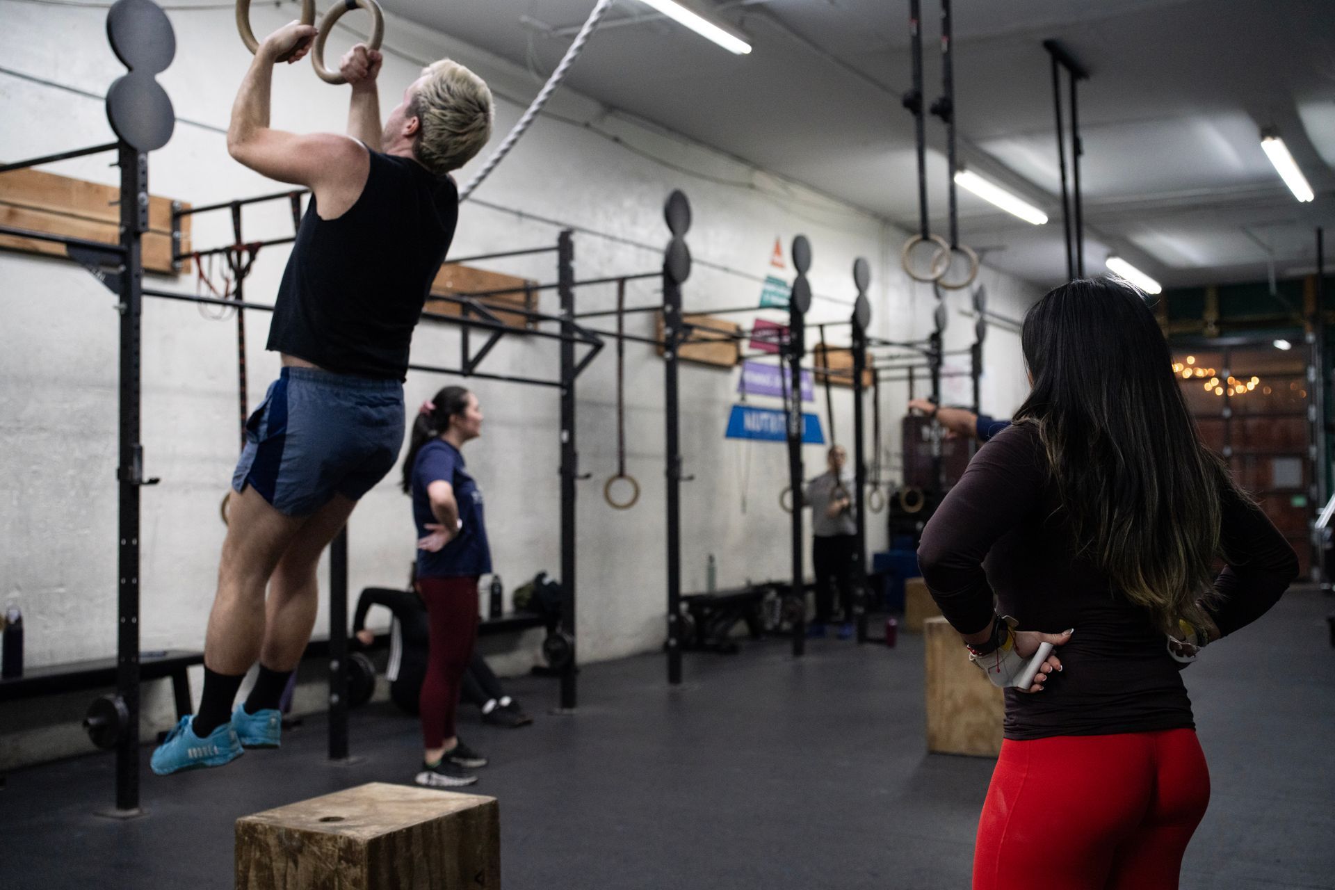 People doing pull-ups and gymnastic exercises in a CrossFit gym