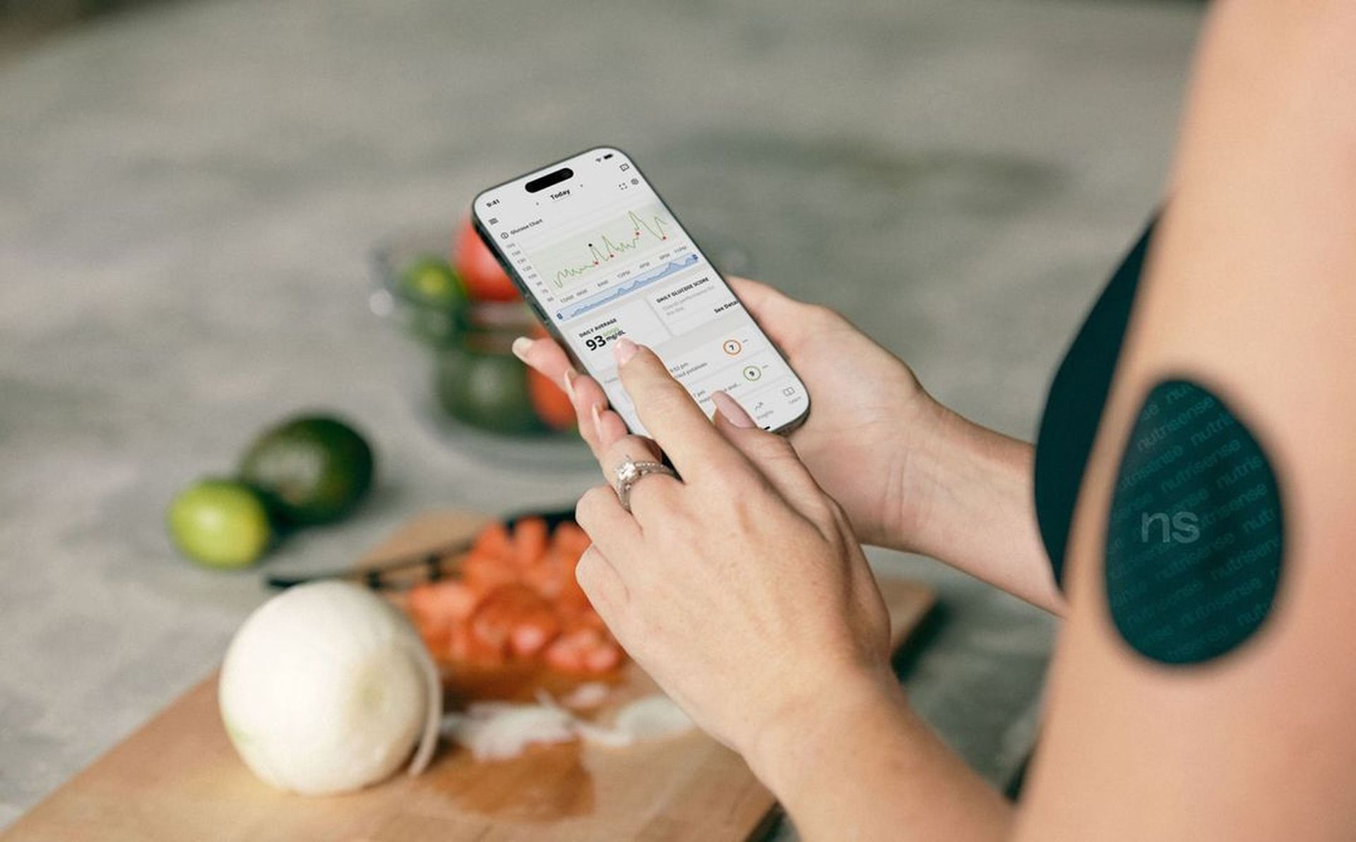 Person using a smartphone to follow a recipe beside chopped vegetables on a cutting board