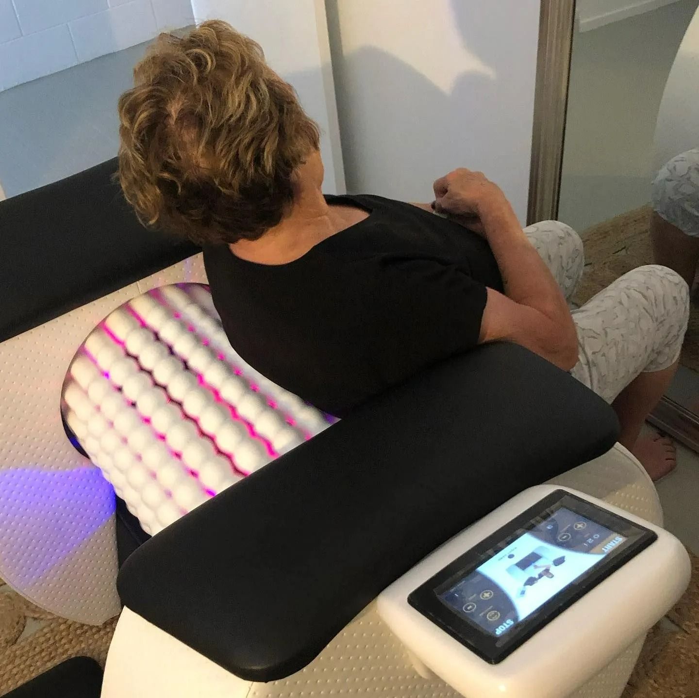 Woman Seated in A Massage Chair, Using a Control Panel — The Colonic Coach in Gulliver, QLD