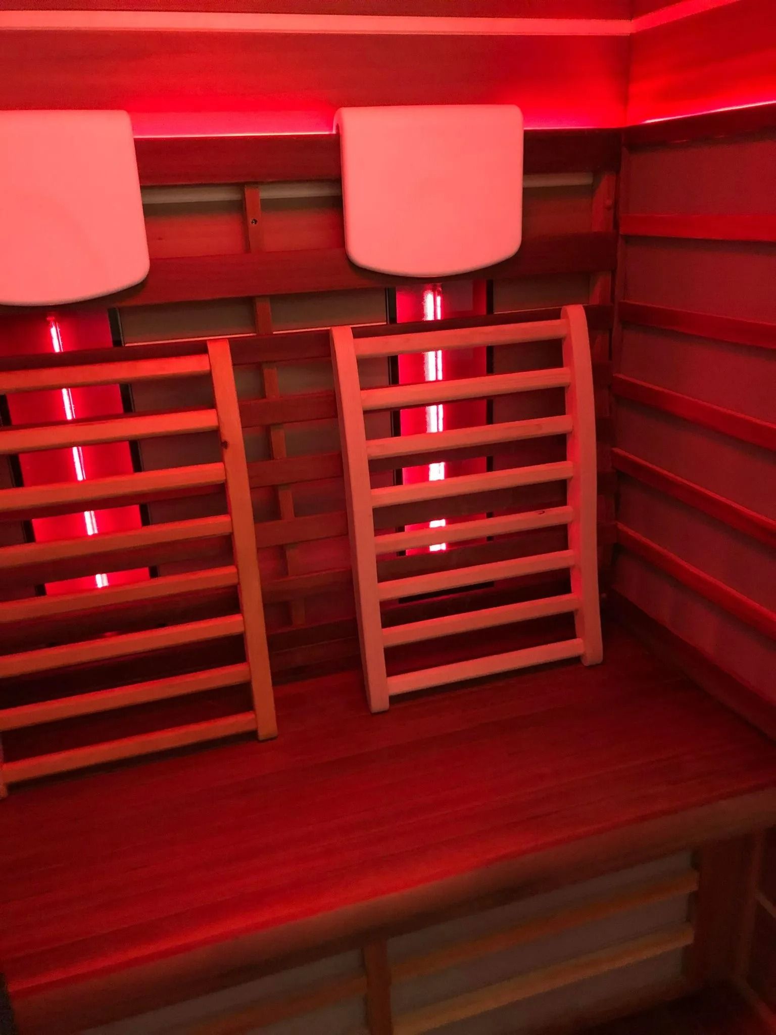 Interior of a Red-lit Infrared Sauna With Wooden Benches — The Colonic Coach in Gulliver, QLD