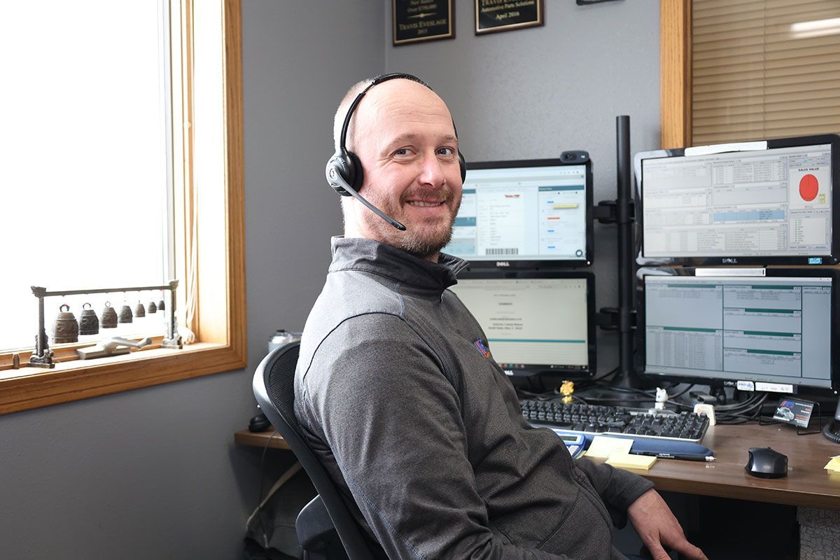 A man wearing a headset is sitting in front of a computer desk.
