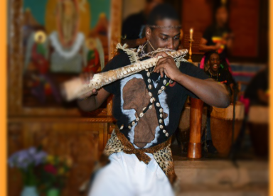 A man in a black shirt is playing a flute
