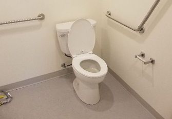 A white toilet is sitting in a bathroom next to a wall.