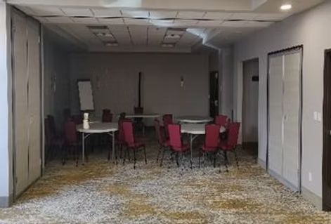 A large room with tables and chairs in it.