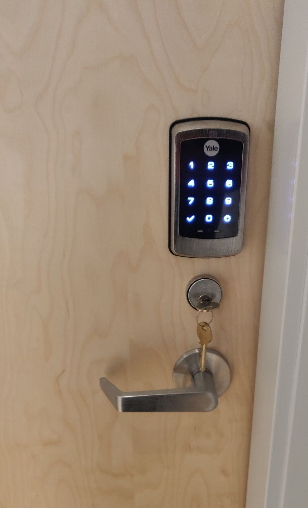 A door with a digital lock and keys on it.