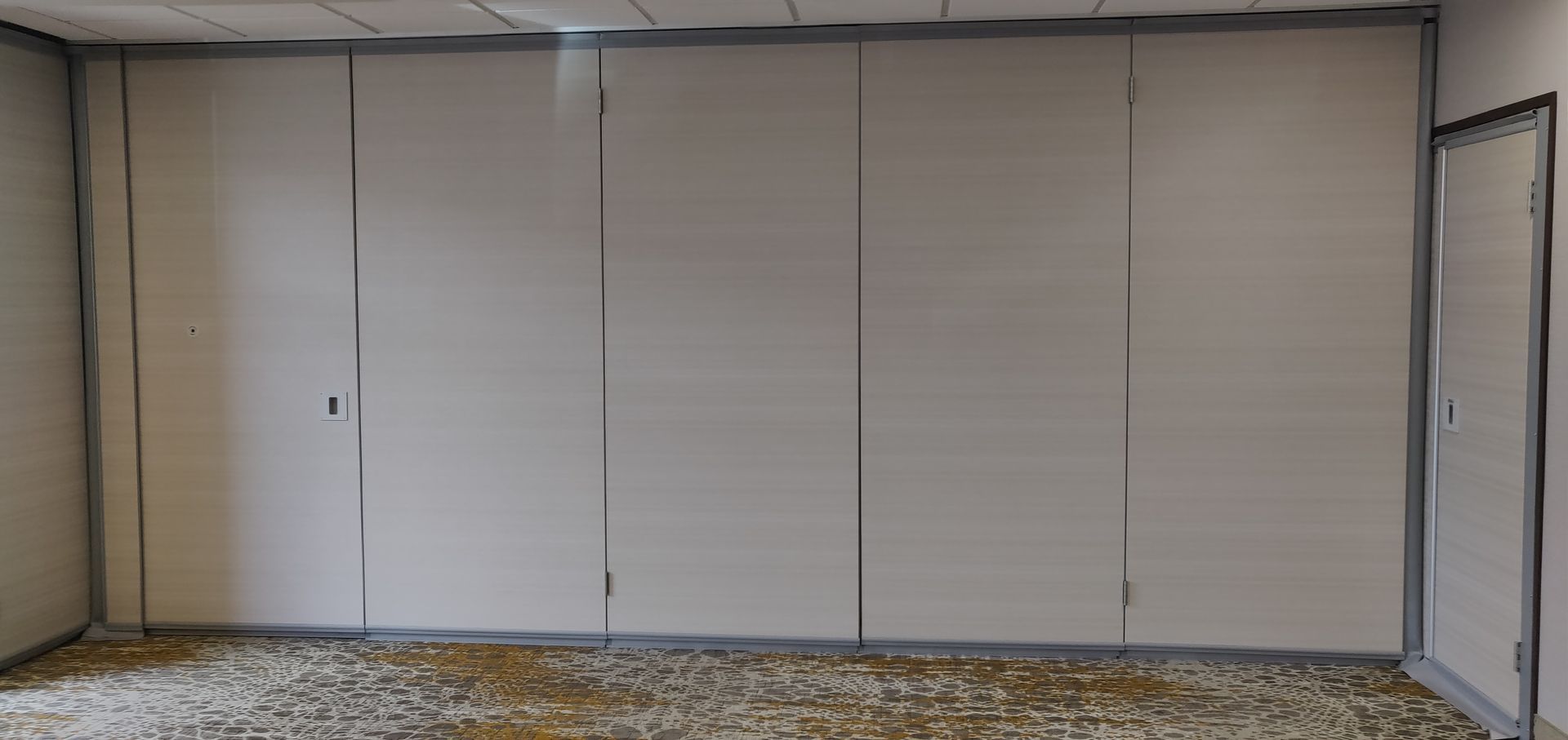 An empty room with a carpeted floor and white walls.