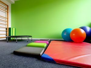 Ein Raum mit einer grünen Wand und einem Trampolin und Bällen