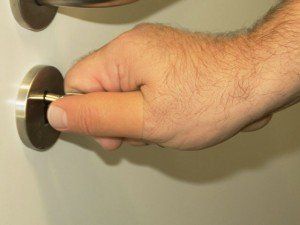 Eine Person öffnet eine Tür mit ihrem Finger.