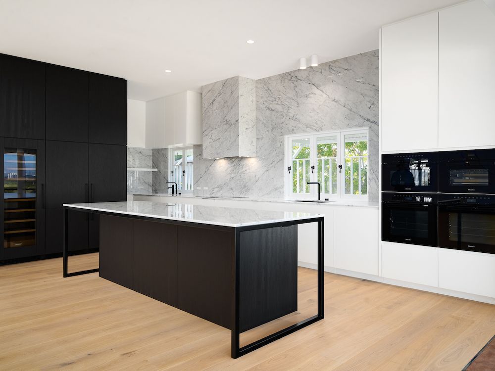 A Kitchen With a Large Black Island in the Middle of the Room — Hot Rock Granite In Byron Bay, NSW