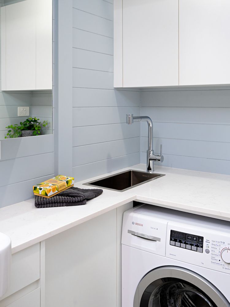 A Laundry Room With a Washing Machine, Sink and Mirror — Hot Rock Granite In Burleigh Heads, QLD