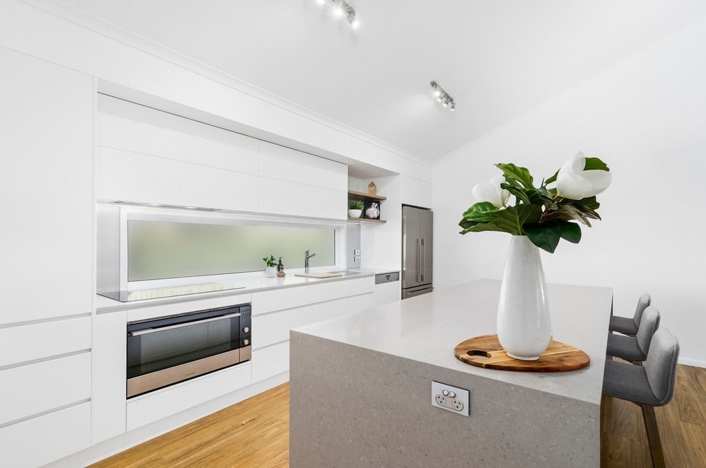 A Kitchen With a Vase of Flowers on the Counter — Hot Rock Granite In Burleigh Heads, QLD