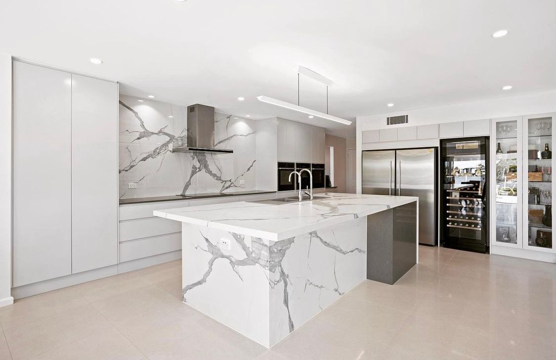 A Kitchen With a Large Marble Island and Stainless Steel Appliances — Hot Rock Granite In Burleigh Heads, QLD