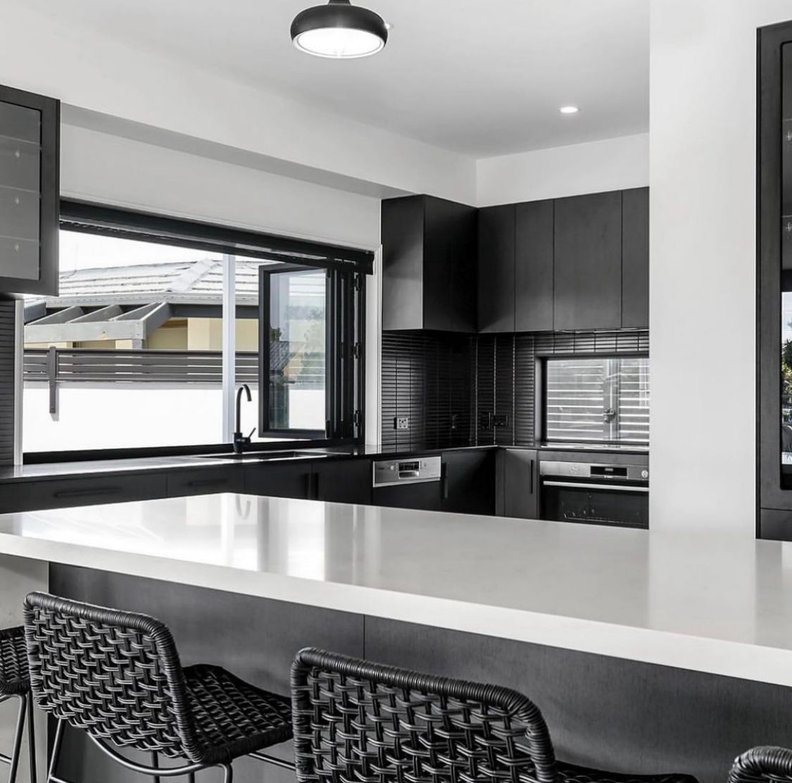 A Kitchen With Black Cabinets and a White Counter Top — Hot Rock Granite In Brisbane, QLD
