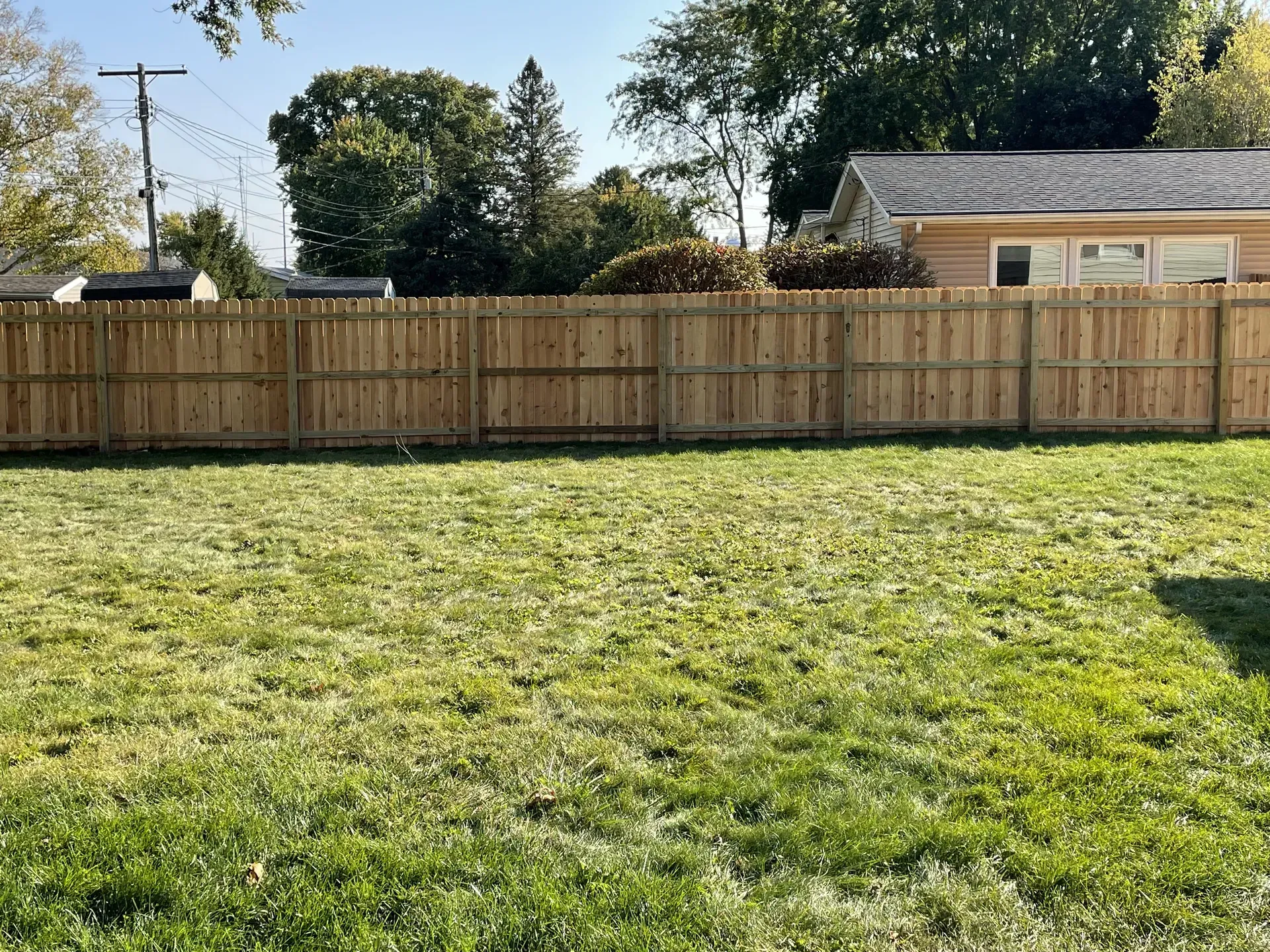 New dog-ear wood privacy fence enclosing a backyard lawn in Madison, WI