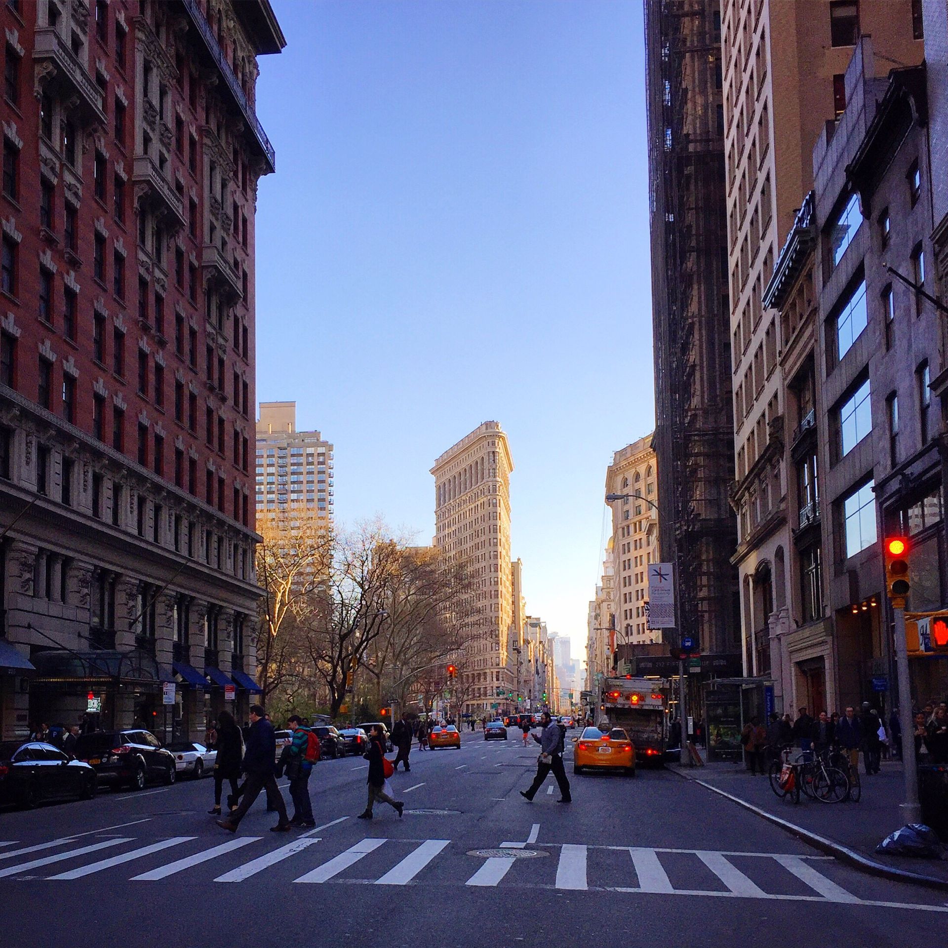 A busy city street with people crossing the street