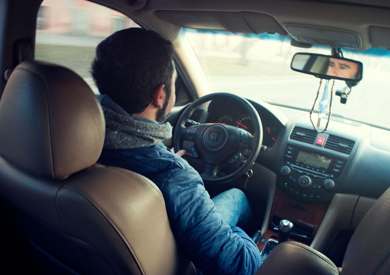 A man is sitting in the driver 's seat of a car.