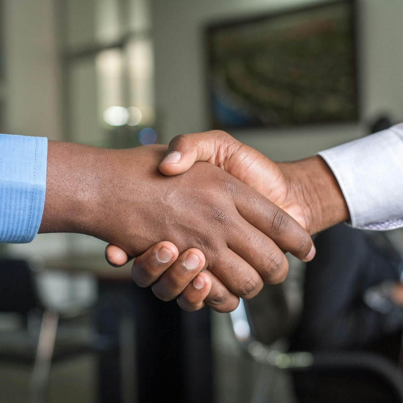 Two men are shaking hands in a room.