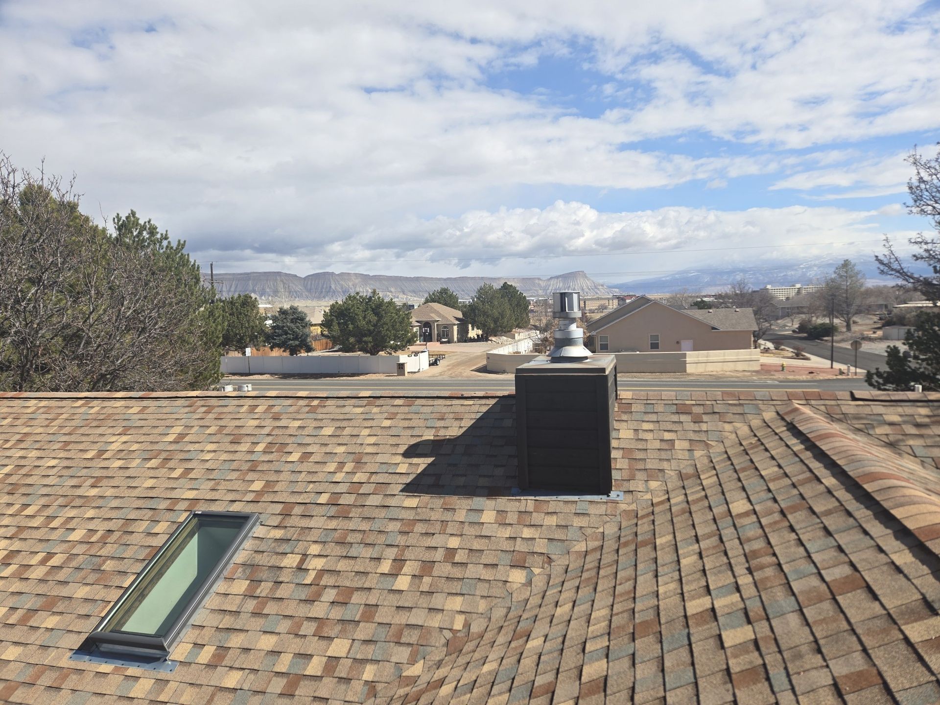 A roof with a skylight and a chimney on it