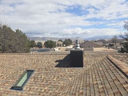 A roof with a skylight and a chimney on it