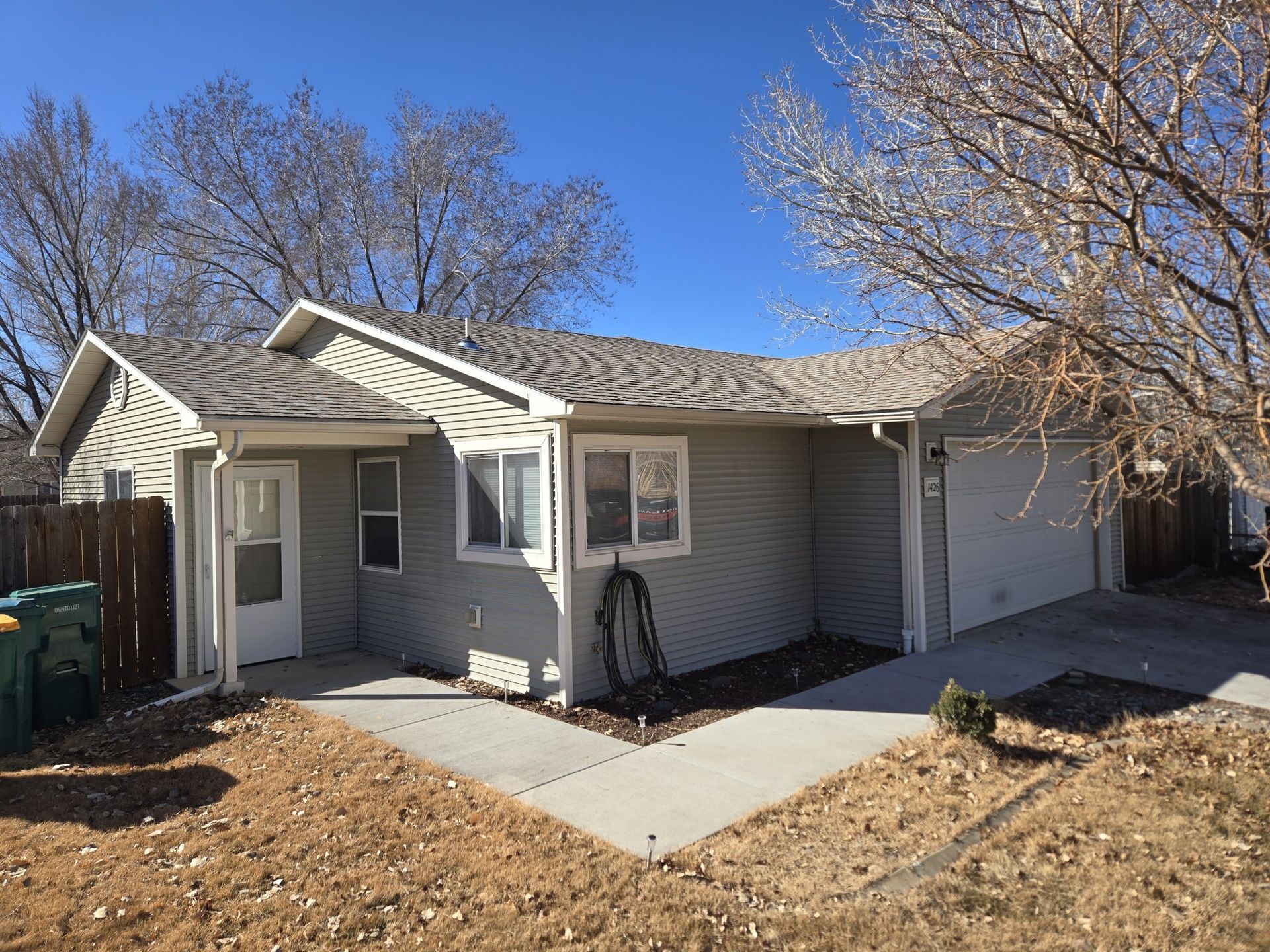 A small house with a concrete walkway in front of it.